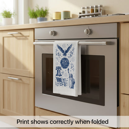 America 250th anniversary navy toile tea towel hanging on an oven handle, showing the full indigo design on white cotton