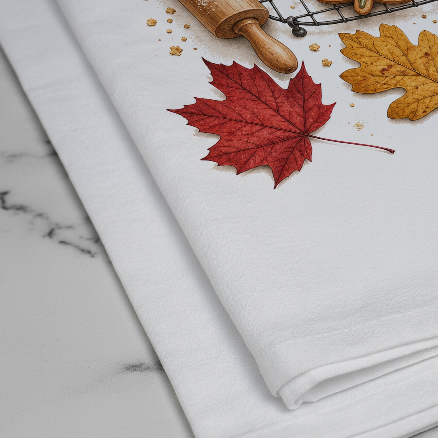 Close-up of the Bake the Leaves Fall Baking Tea Towel print showing leaf-shaped cookies, cooling rack, rolling pin, cinnamon, and autumn leaves on white flour sack organic cotton.