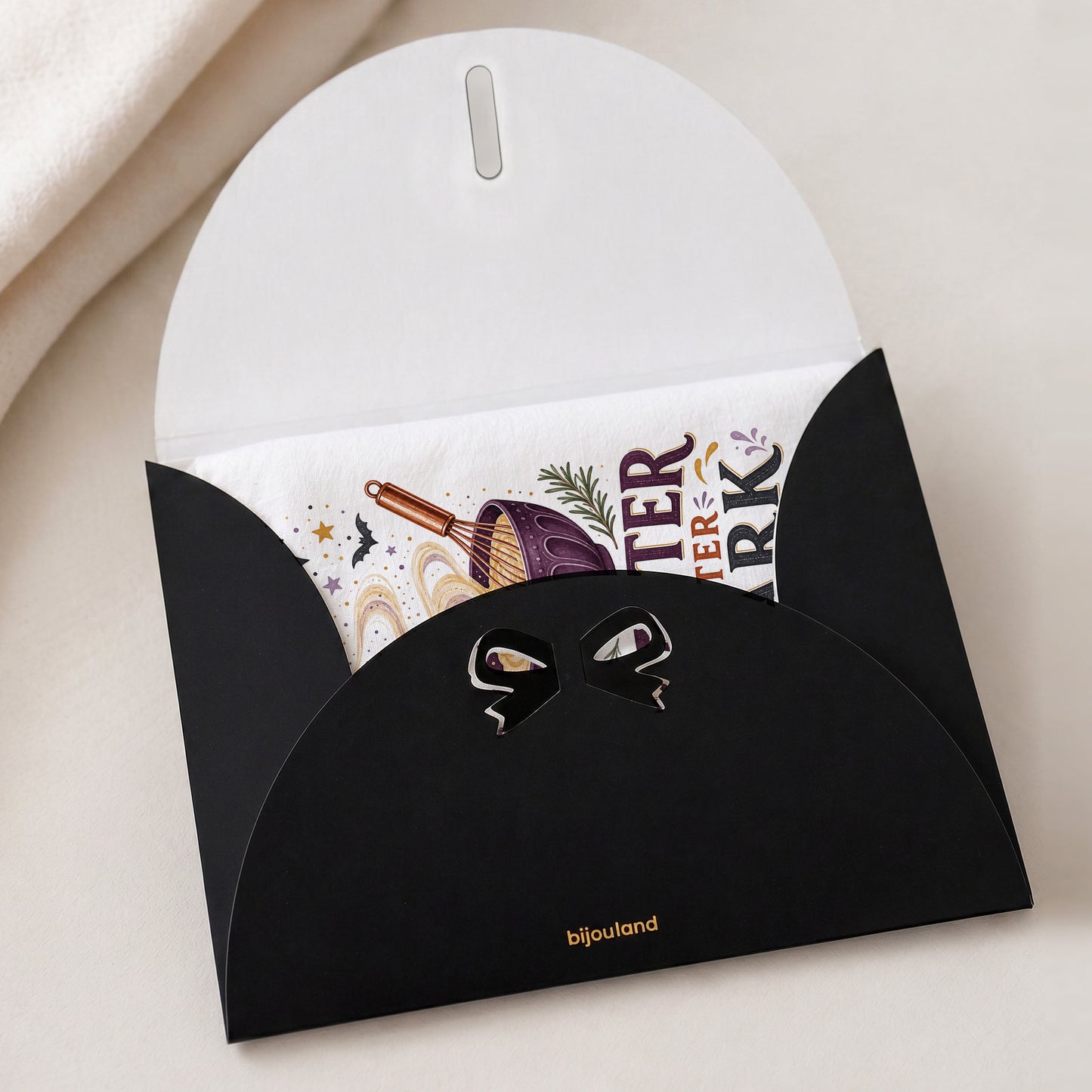 Batter After Dark Halloween Kitchen Towel shown with the black Bijouland gift-envelope packaging option.
