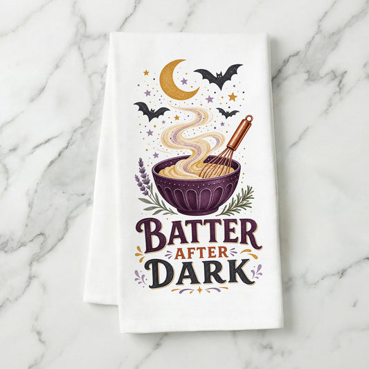 Batter After Dark Halloween Kitchen Towel folded on white marble, with whisk, mixing bowl, curling batter, crescent moon, stars, and bats clearly shown.
