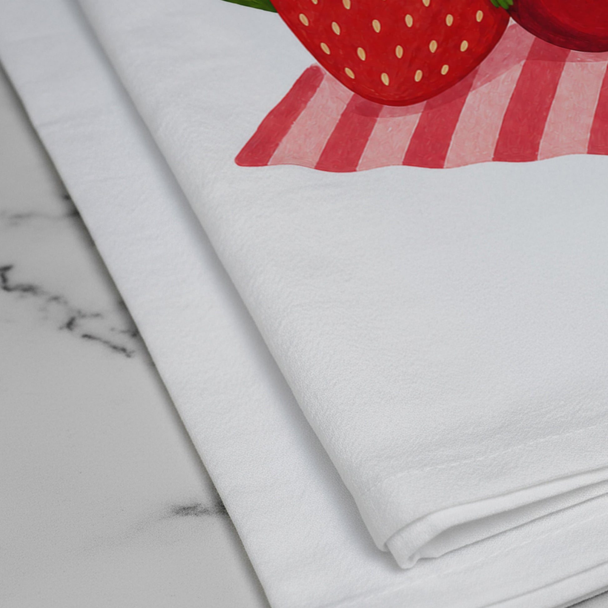 Close-up of the printed strawberry and cherry artwork on the Berry Off Duty cotton tea towel.