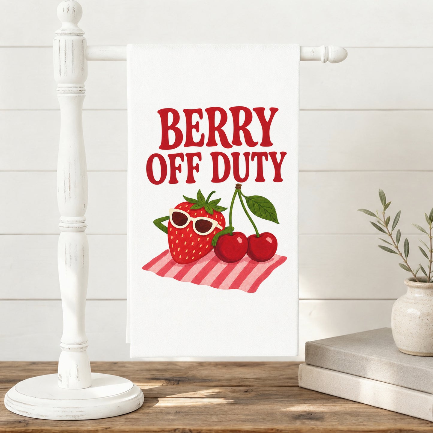 Berry Off Duty strawberry and cherry tea towel displayed on a freestanding towel stand.
