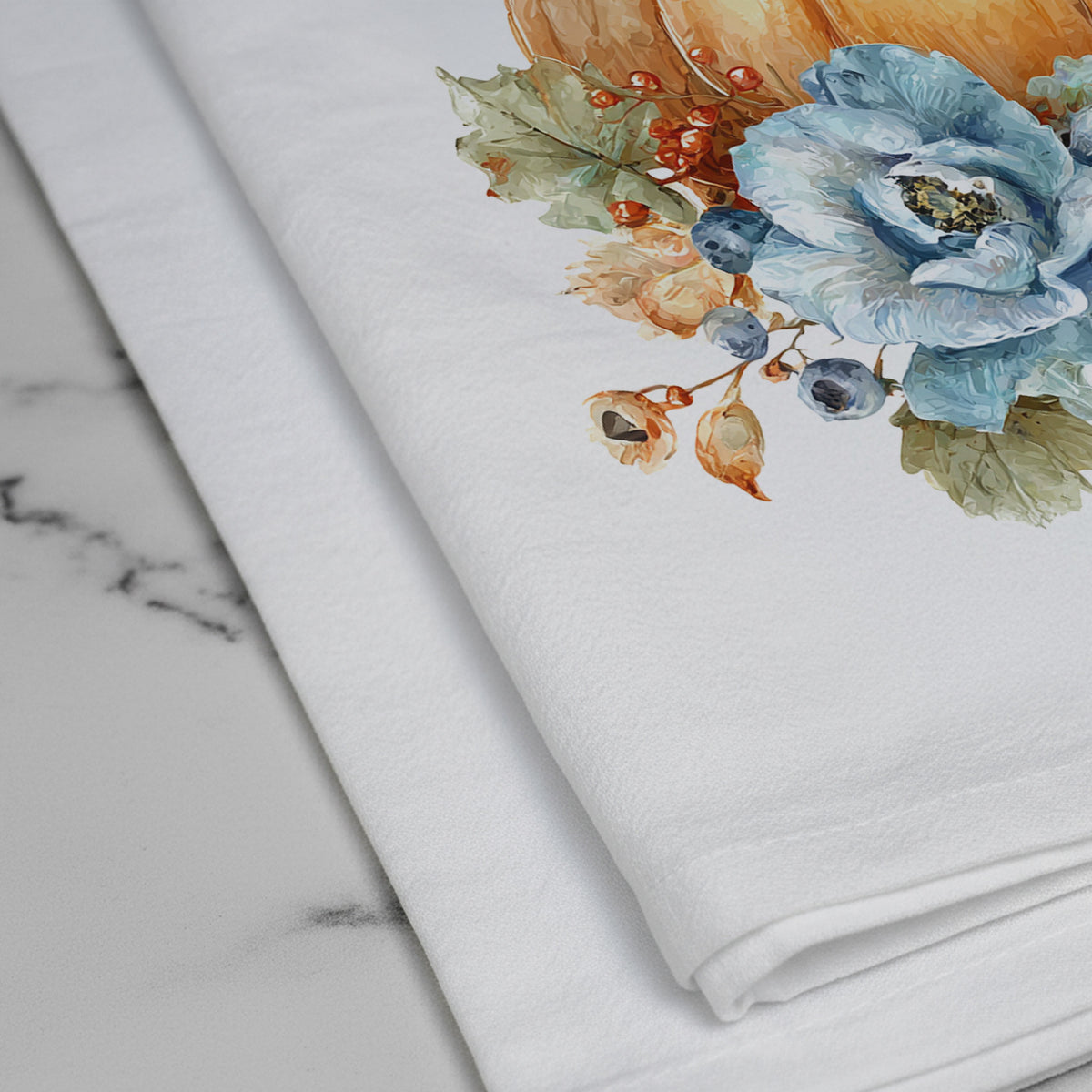 Close-up of the Bluebird Pumpkin tea towel print, showing blue flowers, berries, leaves, and the white flour sack fabric.