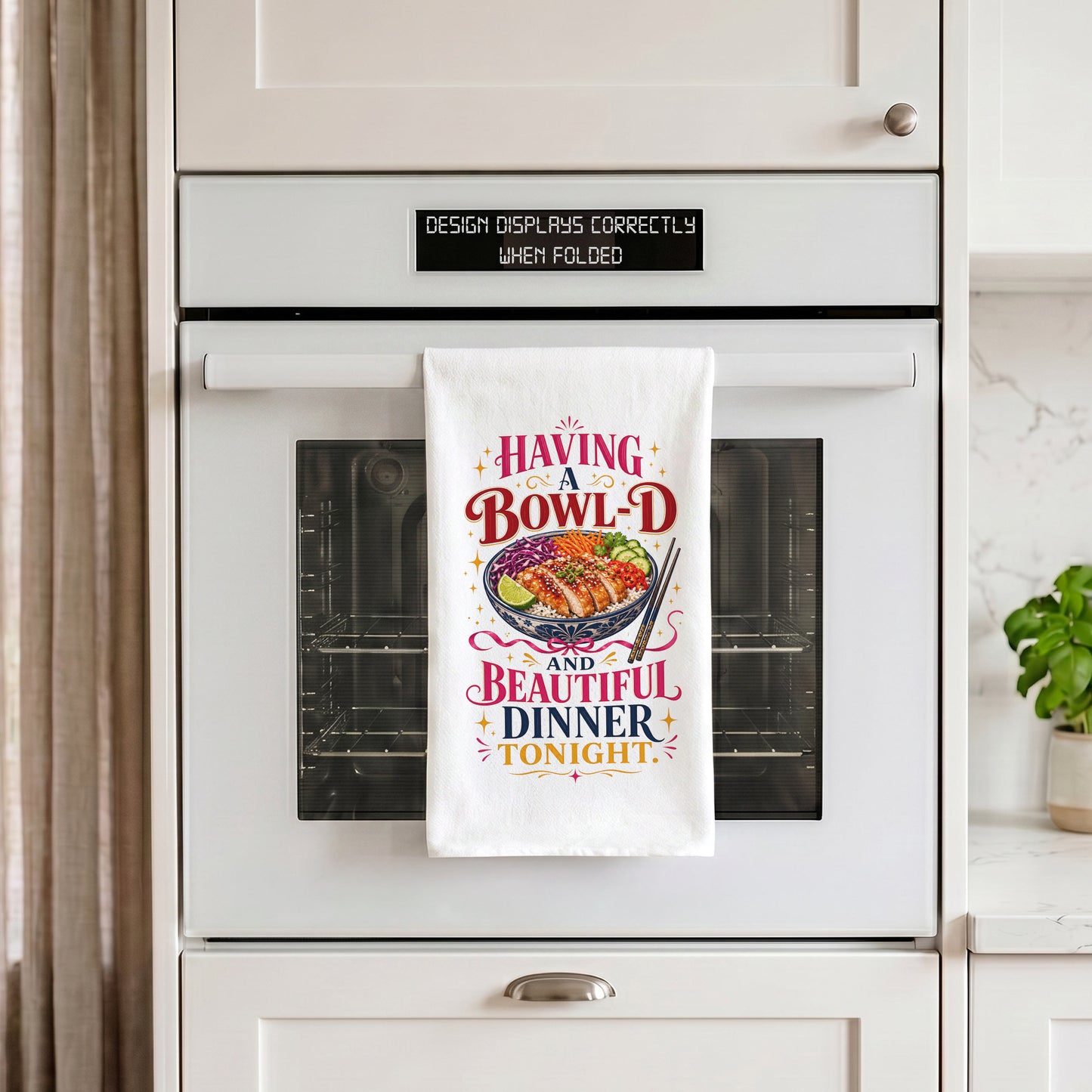 White Bowl-d and Beautiful chicken rice dinner pun kitchen towel draped over an oven handle.