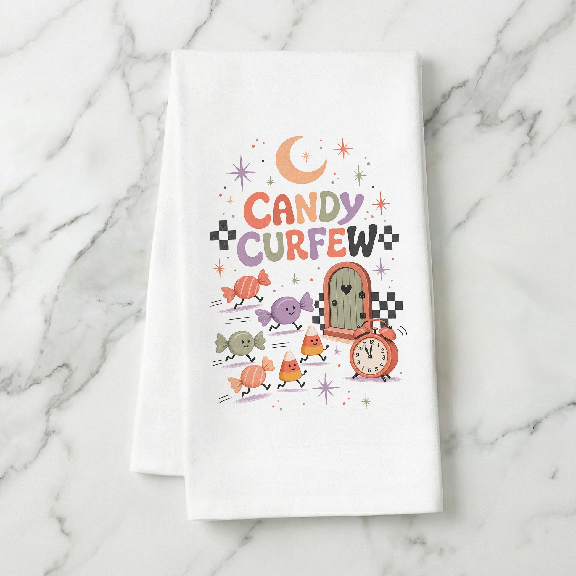 Candy Curfew Retro Halloween Kitchen Towel folded on white marble, with cheerful pastel candies, candy corn, small door, clock, moon, and checkerboard accents clearly shown.