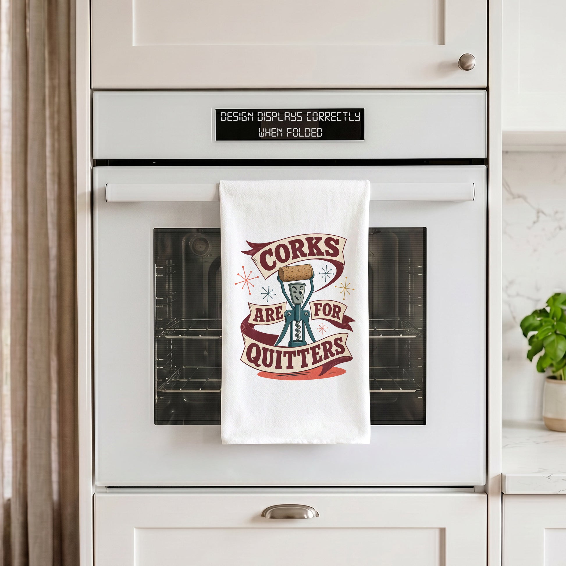 Corks Are for Quitters tea towel hanging from an oven handle.