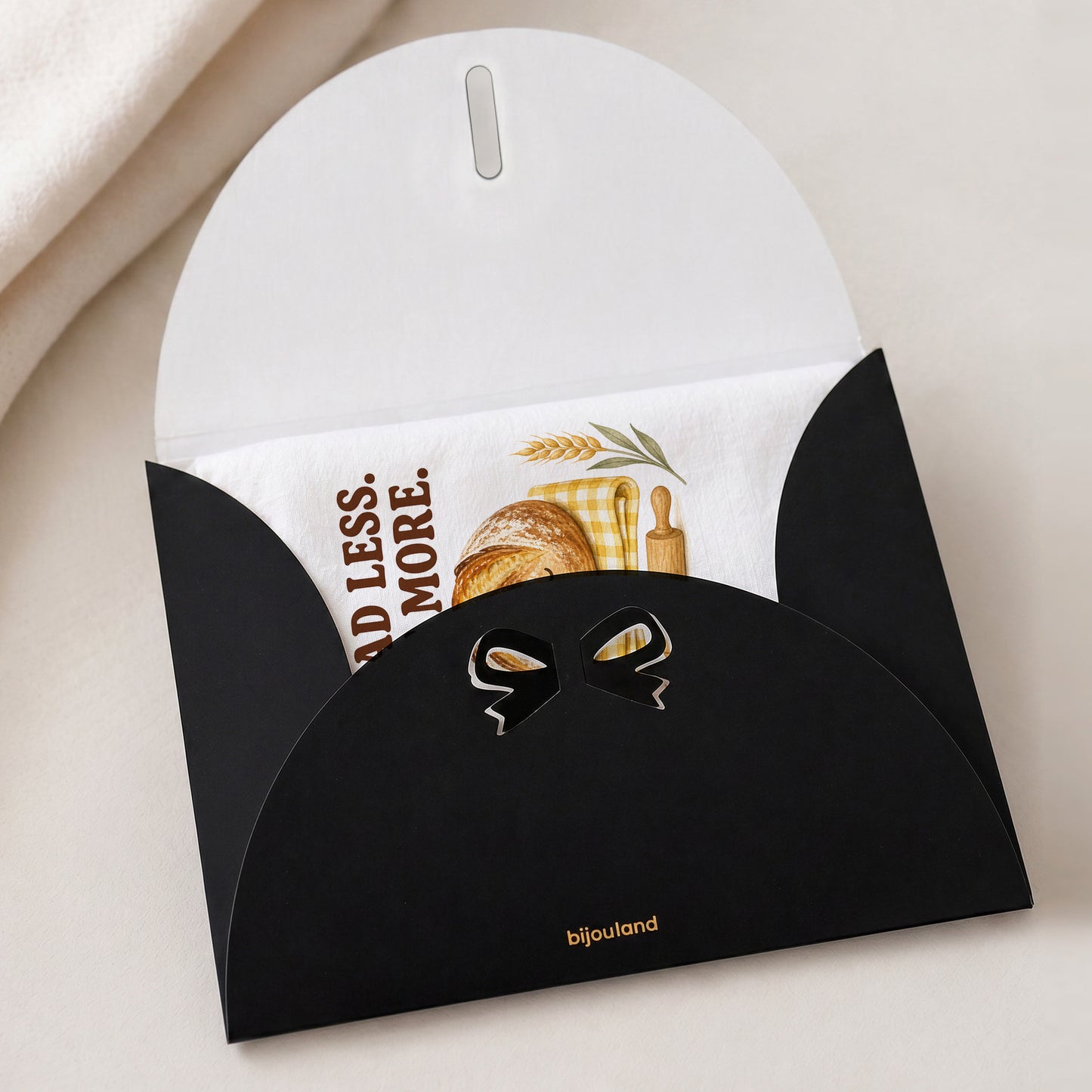 Knead Less Rest More tea towel shown with the Bijouland gift-envelope packaging option.