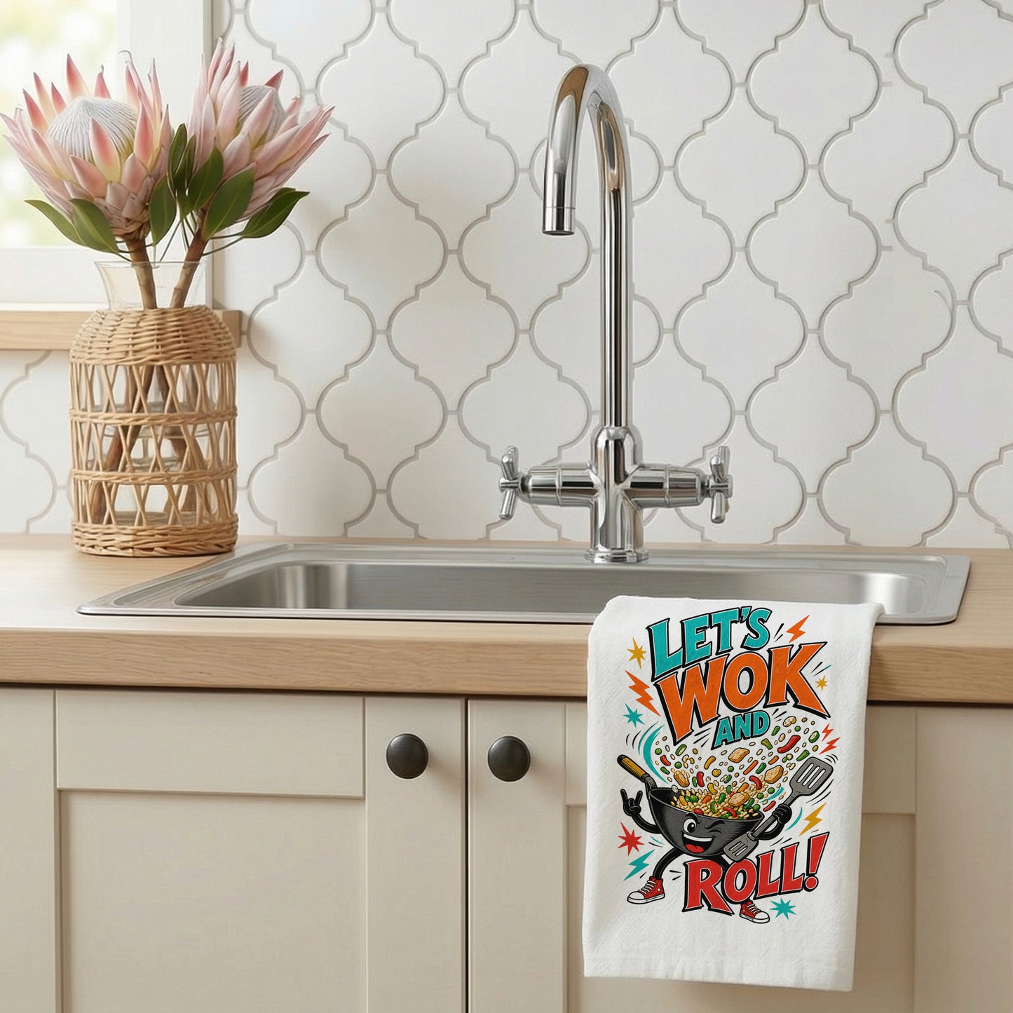 Let's Wok and Roll funny wok cooking pun kitchen towel styled beside a sink with the design visible.