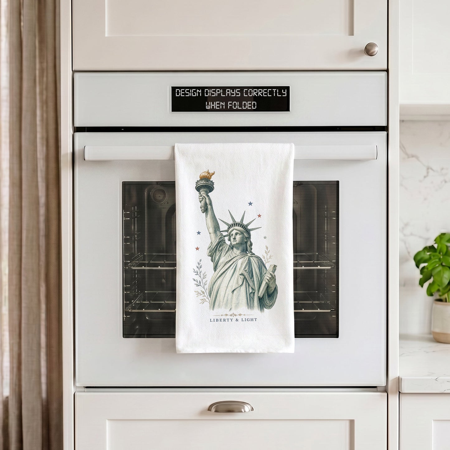 Liberty and Light Statue of Liberty tea towel hanging from an oven handle
