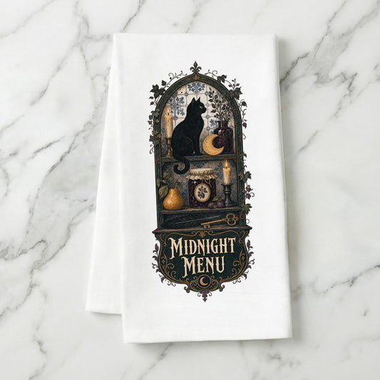 Midnight Menu Black Cat Halloween Kitchen Towel folded on white marble, with black cat, candlelit pantry, moon cookie, pear, preserves, and antique details clearly shown.