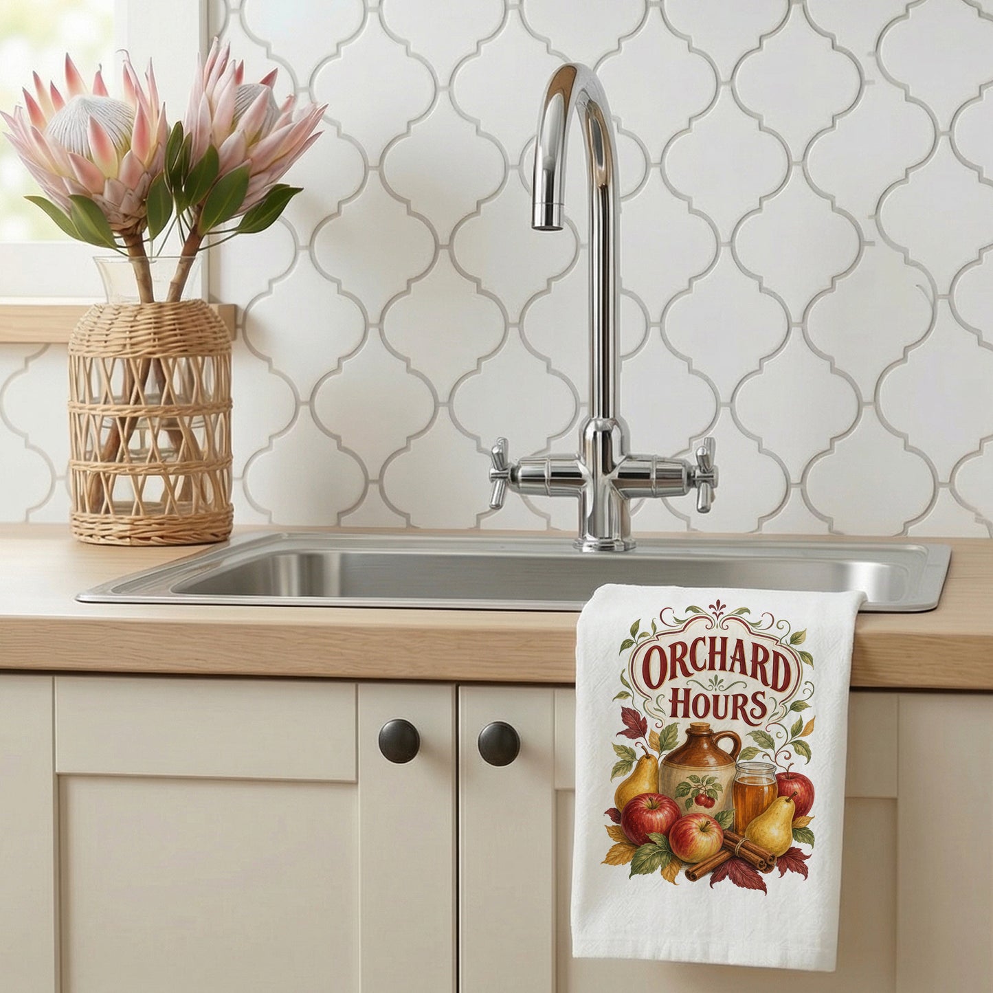 Orchard Hours Apple Cider Tea Towel styled beside a bright kitchen sink, with apples, pears, cider jug and glass, cinnamon sticks, leaves, and vintage lettering shown.