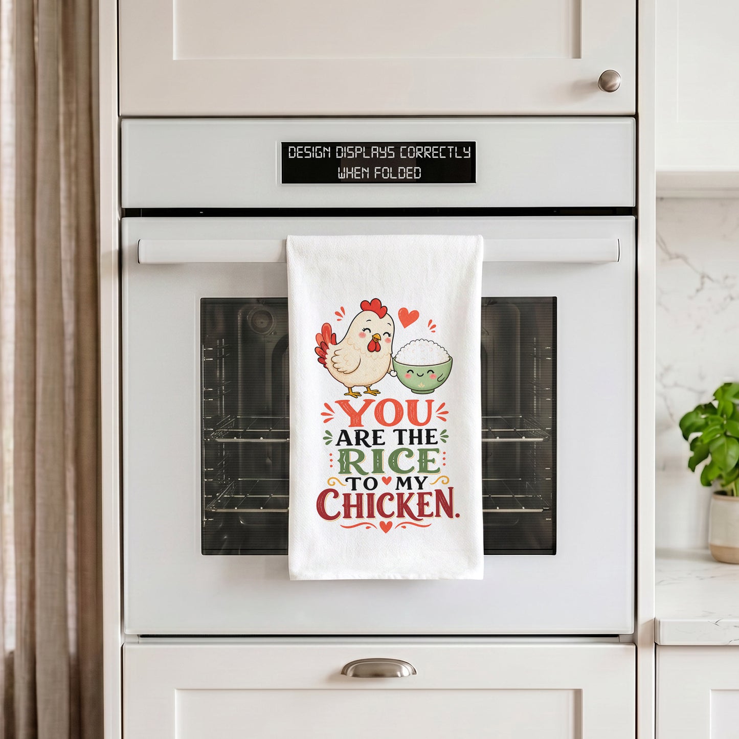 White You Are the Rice to My Chicken kawaii food pun kitchen towel draped over an oven handle.