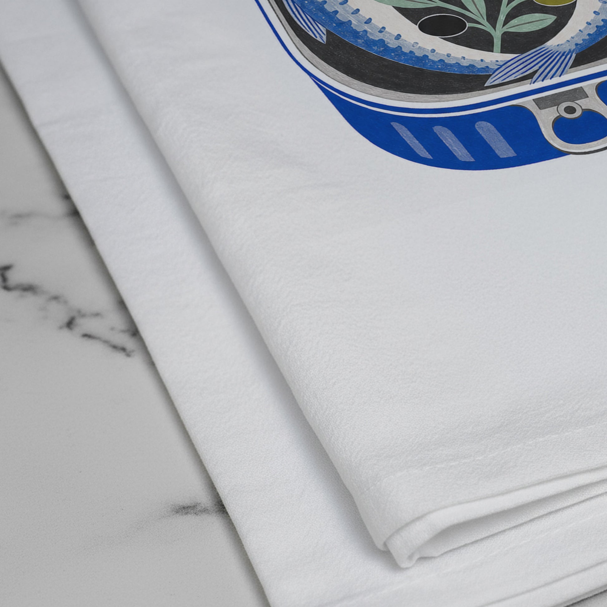 Close-up of the printed sardine and lemon artwork on the Sardinely Yours cotton tea towel.