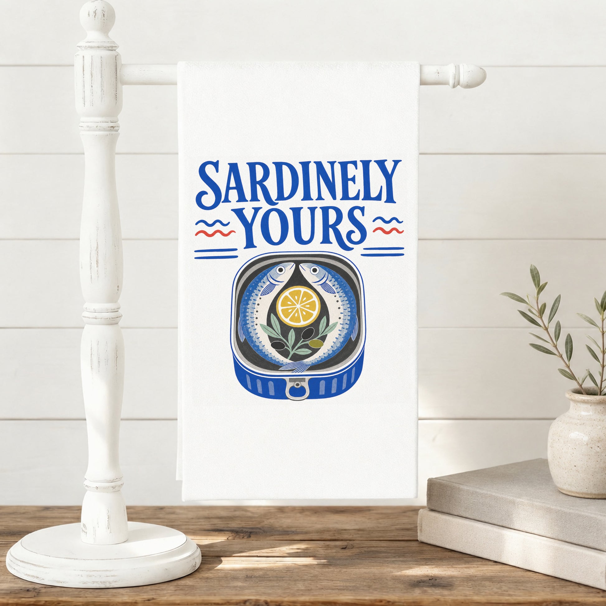 Sardinely Yours sardine and lemon tea towel displayed on a freestanding towel stand.