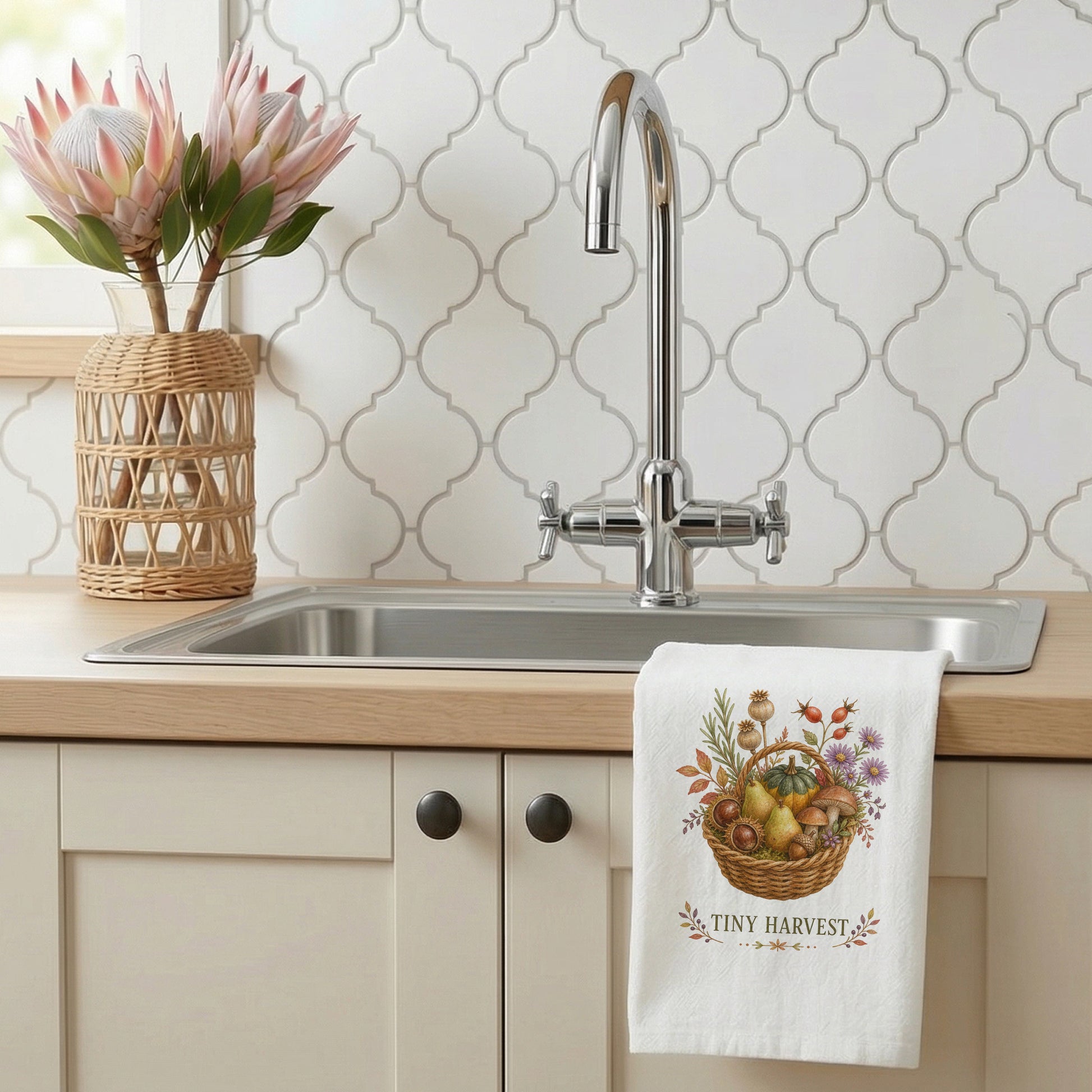 Tiny Harvest Autumn Tea Towel styled beside a bright kitchen sink, with woven basket filled with pears, squash, mushrooms, chestnuts, herbs, and flowers shown.