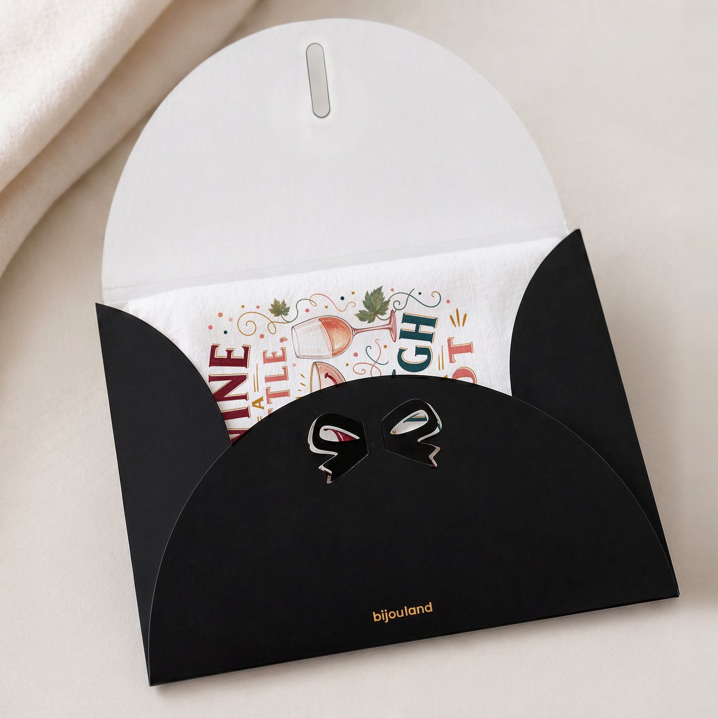 Wine a Little, Laugh a Lot tea towel shown with the Bijouland gift-envelope packaging option.