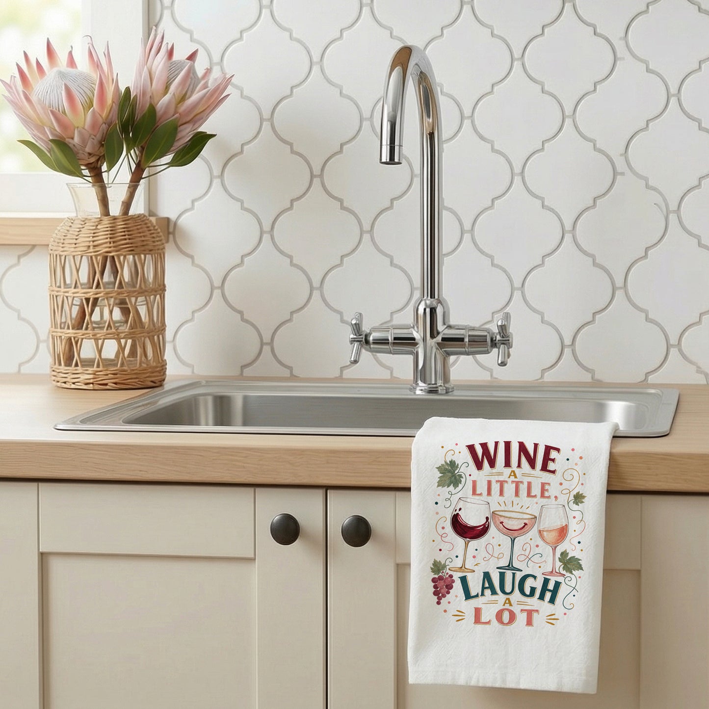 Wine a Little, Laugh a Lot tea towel styled beside a kitchen sink.